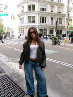 Woman in a leather jacket and wide leg jeans on a city street