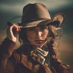 Woman in a cowboy hat with a long braid and windblown hair