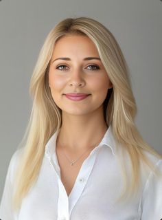 Blonde woman with long hair wearing a white shirt and necklace in a studio portrait