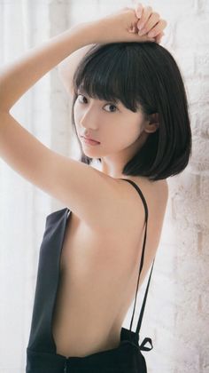 Woman with short black hair in a black dress with an exposed back