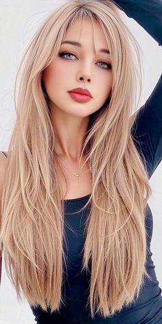 Woman with long blonde hair and red lipstick wearing a black top and necklace