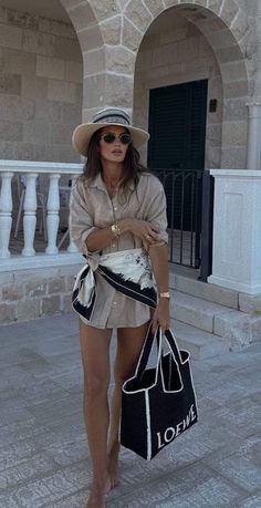 Woman in a straw hat and sunglasses wearing a long sleeve shirt and scarf