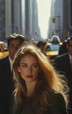 Woman with long blonde hair and red lipstick on a busy city street