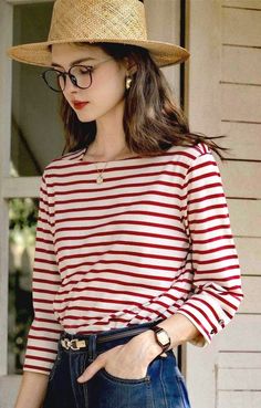Woman in a straw hat and striped shirt with glasses and long hair