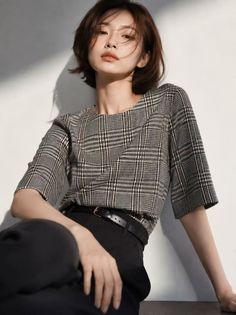 Woman with short hair in a plaid shirt and black pants with dramatic lighting