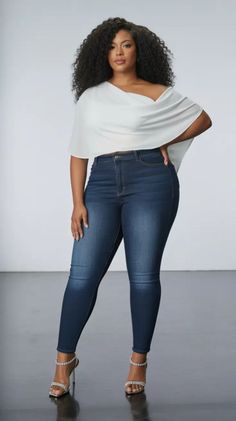 Woman with curly hair wearing an off-shoulder top and dark wash jeans