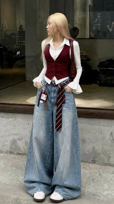 Woman with blonde hair wearing a red vest and wide leg jeans