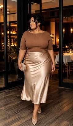 Woman in a brown top and satin skirt standing in a restaurant