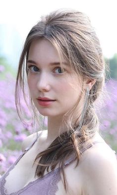 Woman with long hair and lace top in a field of purple flowers