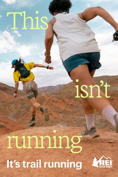 Two people trail running on a dirt path in a desert landscape