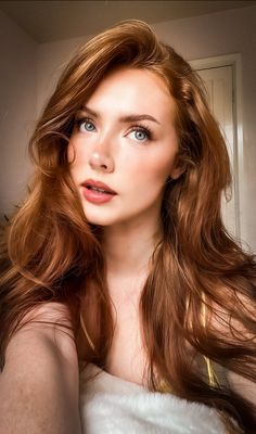 Woman with long red hair and blue eyes looking up