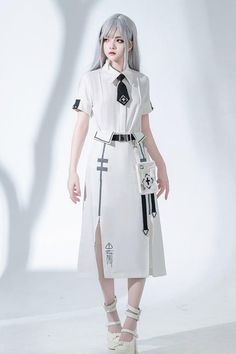 Woman with silver hair in a white dress and black tie in a studio