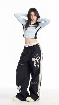 Woman in a light blue crop top and black baggy pants with lace trim