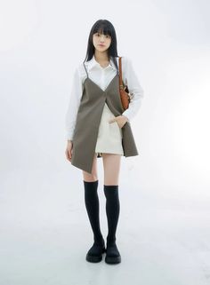 Woman with long black hair wearing a white shirt and sleeveless top with a mini skirt