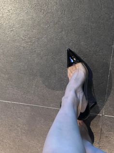 Person wearing black and clear high heels on a tiled floor