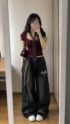 Woman in a crop top and wide leg jeans taking a mirror selfie