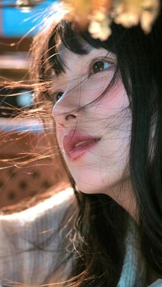 Close up portrait of a woman with windblown black hair in golden hour light