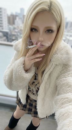 Blonde woman in a fur jacket and plaid skirt smoking outdoors