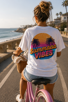 Woman riding a pink bicycle on a beach road, seen from behind