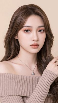 Woman with long brown hair wearing an off-shoulder top and a necklace