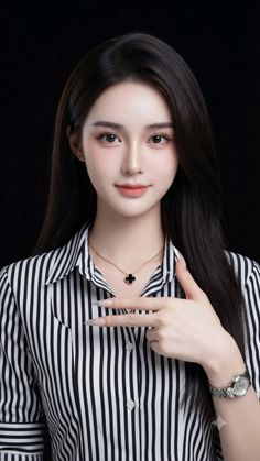 Woman with long dark hair wearing a striped shirt and a clover necklace