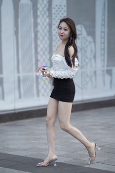 Woman in an off-shoulder top and mini skirt walking outdoors
