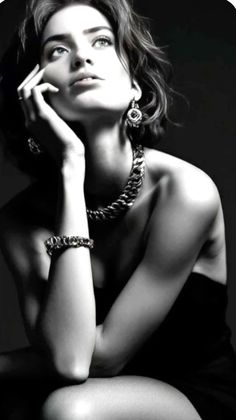 Woman with short hair and jewelry in a dramatic black and white portrait