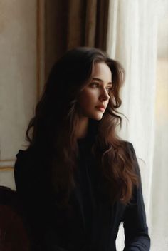 Woman with long dark hair looking out a window with soft lighting