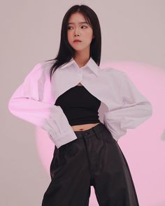 Woman in a white cropped shirt and black crop top with exposed midriff