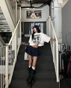 Woman in a denim skirt and crop top posing on a staircase