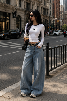 Woman in a crop top and wide leg jeans on a city street