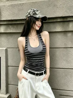 Woman in a camo hat and striped top with white pants, posing outdoors