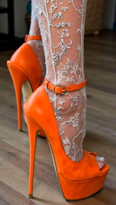 Close up of feet in orange platform heels and lace stockings