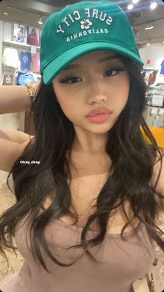 Woman with long black hair and a green cap in a store