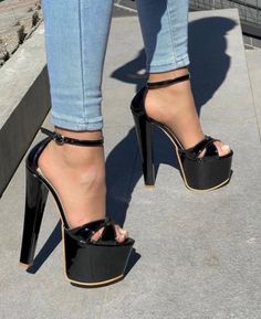 Person wearing black platform high heels and jeans outdoors