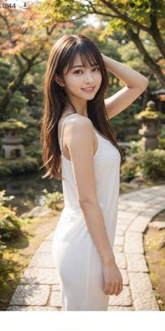 Woman in a white dress posing in a garden with stone lanterns