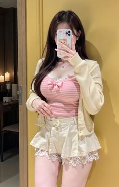Woman in a pink striped top and mini skirt taking a mirror selfie