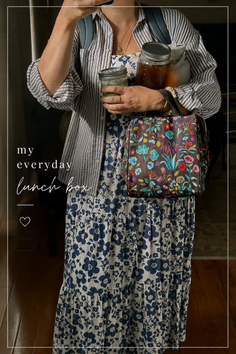 Person holding a floral lunch bag and mason jars, wearing a floral dress and striped shirt