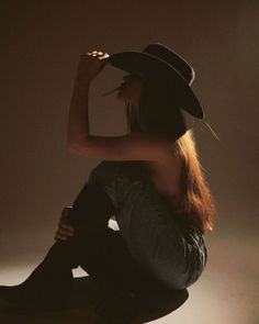 Woman in a cowboy hat and jeans, with long hair and backlight