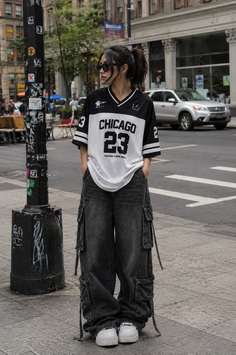 Woman in an oversized jersey and cargo pants on a city street