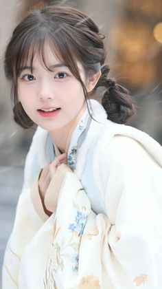 Young woman in traditional Chinese clothing with pigtails outdoors