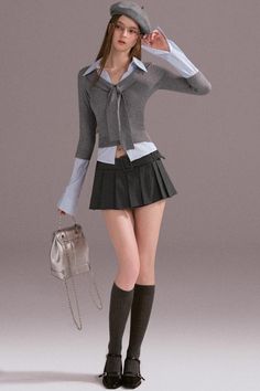 Woman in a pleated skirt, beret, and knee-high socks holding a silver bag