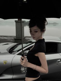 Woman with an umbrella next to a silver car by a lake on an overcast day