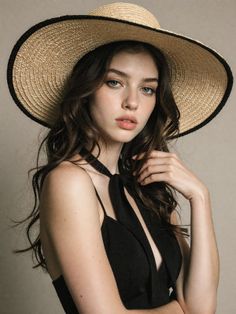 Woman in a straw hat and black top with deep cleavage
