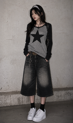 Woman with long dark hair wearing a star print shirt and wide leg jeans