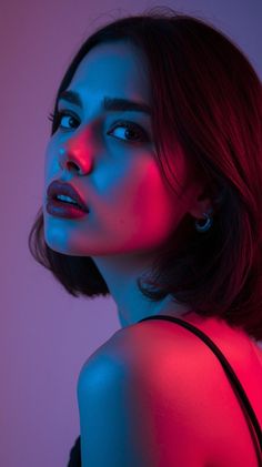 Woman with short hair and red lipstick under blue and red neon lighting
