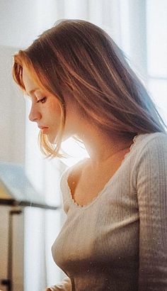 Woman with long hair in a white top with soft backlight