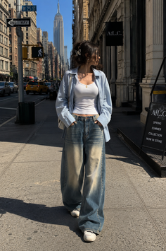 Woman in baggy jeans and a light blue shirt on a city street