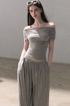 Woman in an off-shoulder top and wide-leg pants with sunglasses on her head
