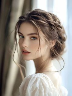 Woman with braided updo and white dress in soft indoor lighting